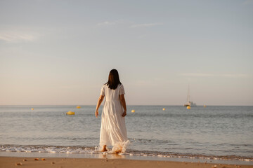 Fototapeta na wymiar Luxury portrait of woman in white dress at the beach, Algarve, Portugal