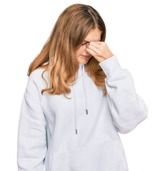 Beautiful young caucasian girl wearing casual sweatshirt tired rubbing nose and eyes feeling fatigue and headache. stress and frustration concept.