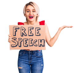 Young beautiful blonde woman holding free speech banner celebrating victory with happy smile and winner expression with raised hands