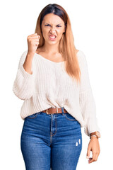 Fototapeta premium Beautiful young woman wearing casual clothes angry and mad raising fist frustrated and furious while shouting with anger. rage and aggressive concept.