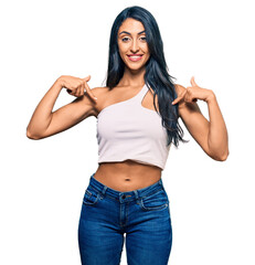 Beautiful hispanic woman wearing casual clothes looking confident with smile on face, pointing oneself with fingers proud and happy.