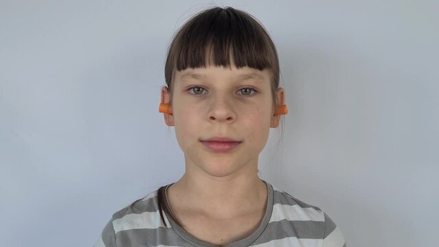 Individual earplugs for children. Girl holds separate earplug near her ear closeup