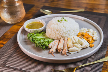 Boiled chicken rice mixed with crab meat on a wooden table