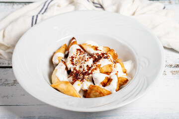 Turkish ravioli. Ravioli with yoghurt and sauce on a white background