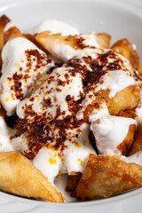 Turkish ravioli. Ravioli with yoghurt and sauce on a white background. Close up
