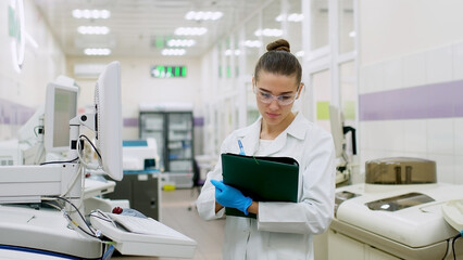 A female scientist controls the operation of devices for laboratory research. Modern laboratory...