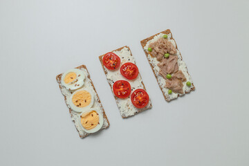 Ingredients for sandwich with boiled egg, cherry tomatoes, canned tuna, garlic and spices on grey white background. High quality photo