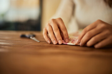 Close-up of a female hands, wrapping a gift in decoration paper.