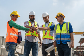 Group of diverse teamwork civil engineers foreman and workers wear safety vests with helmets stand...