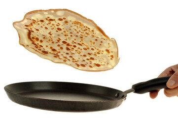 Faire sauter une crêpe de la crêpière en gros plan sur fond blanc