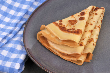 Crêpe pliée en triangle dans une assiette en gros plan