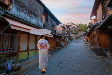 Scenic sunset of Nineizaka or Ninenzaka, ancient pedestrian road in Kyoto, Japan with a young Japanese woman in a traditional Kimono dress