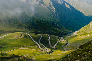 Mountain pass in Georgia in summer. Views from one of the most dangerous road on the world in Georgia. Road to Omalo.  Abano pass in the Caucasus mountains. Top view of winding road. - obrazy, fototapety, plakaty