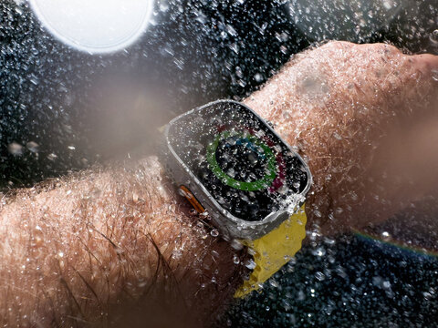 Paris, France - Sep 23, 2022: A detailed view of a person wearing a watch from Apple Computers, model Ultra 2 under heavy rain showcasing the watchs water-resistant capabilities following a rainfall