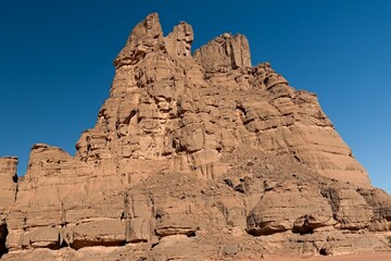 View of Tamezguida rock formation in Tadrart Rouge rocky mountain range in Tassili n Ajjer National Park. Sahara desert, Algeria, Africa.