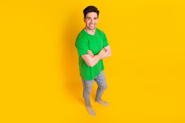 Fototapeta na wymiar Full size photo of positive cheeful optimistic guy wear stylish t-shirt standing hold hands crossed isolated on yellow color background