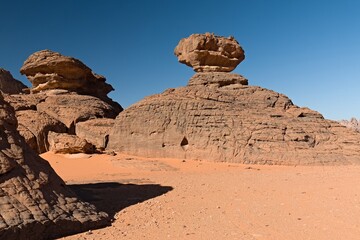 Fototapeta na wymiar View of Tamezguida rock formation in Tadrart Rouge rocky mountain range in Tassili n Ajjer National Park. Sahara desert, Algeria, Africa.