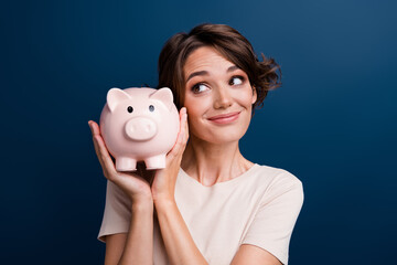 Photo portrait of pretty young girl look admire hold piggy account bank wear trendy white outfit...
