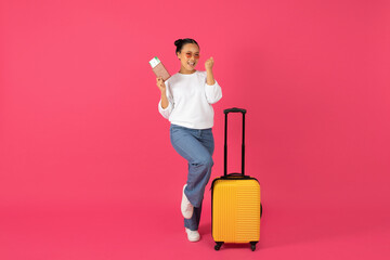 Joyful young asian traveler woman holding passport with tickets and celebrating success