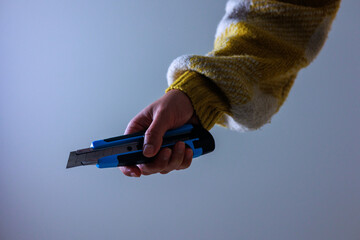 ニットを着た若い女性がカッターを握る