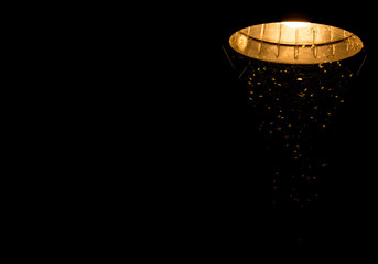 Luminária de teto acesa de noite com teia de aranha.