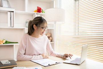 Young woman using a laptop, Work from the comfort of home, Use your laptop for work and communication, Work from home.