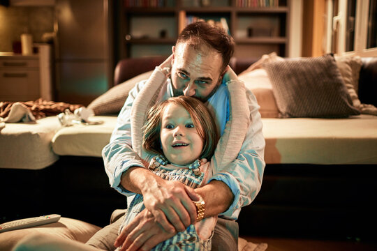 Father and daughter embracing during movie time at home