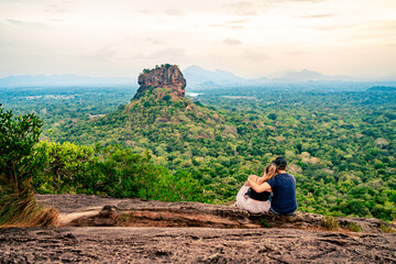 Couple in Sigiriya, rock view. Woman and man, summer travel. People on vacation in Sri Lanka. Beautiful nature with green landscape and mountains. Romance on Pidurangala. Honeymoon tourism. - obrazy, fototapety, plakaty