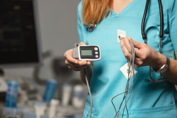 Doctor showing ECG holter monitor to patient in pediatric clinic. Holter monitoring device in a...