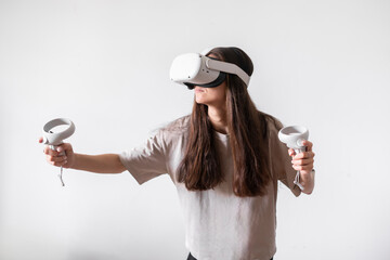 A woman, equipped with virtual reality glasses and controllers, actively plays games in an indoor...