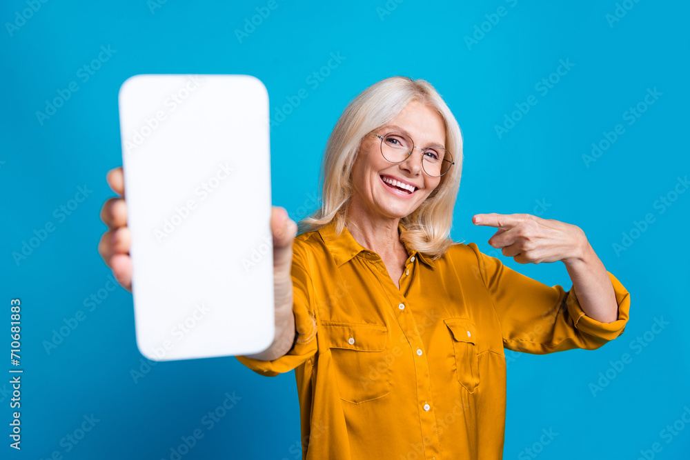 Sticker Photo of pretty retired female point white display telephone promo wear trendy yellow silky outfit isolated on blue color background