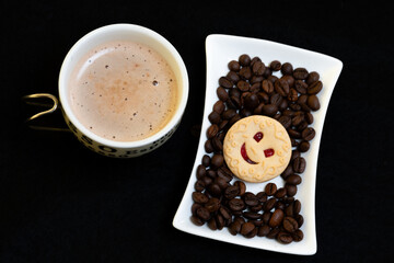 cup of coffee, coffee beans and smiling cookie, top view
