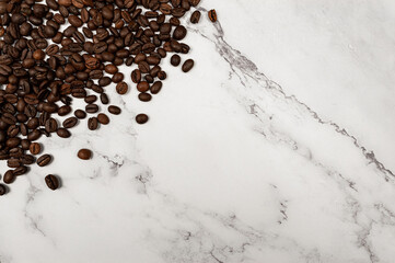 Top view of coffee beans on white marble background. Flat lay, copy space.