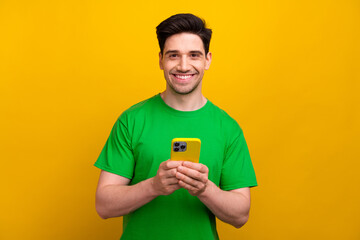 Portrait of young cheerful handsome man wear green t shirt hold cell phone at his job organize...
