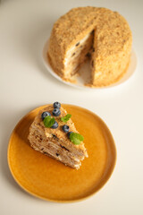 Homemade baked cake Napoleon, Millefeuille. Delicate custard cake garnished with berries and mint. On a gray concrete stone background. High quality photo