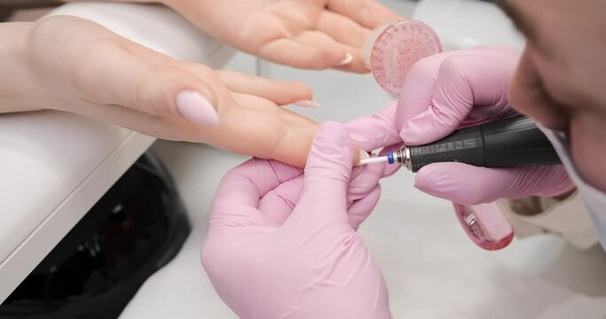 Finalization of nails for gel nail polish cover in the salon, master.