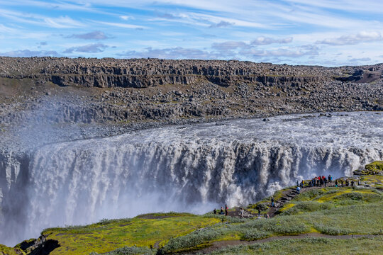 People at cliff edge Dettifoss waterfall