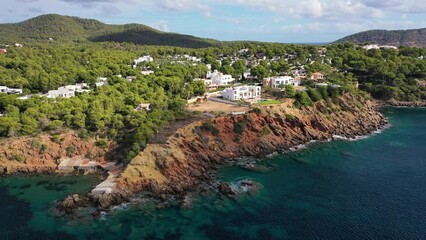 Aerial view of luxury hotels along the coastline with high cliffs facing the Mediterranean Sea, Ibiza, Balearic Islands, Spain.