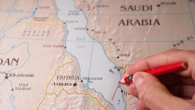 hand drawing a red line and closing  the maritime passage through the Red Sea. Concept of Attacks by Pirates and Iran-backed militants in the Red Sea and the Houthi strikes.