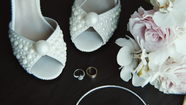 Wedding morning. A bride's bouquet of white flowers with  women's high-heeled shoes, a diamond engagement ring. 