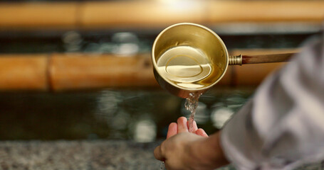 Temple, closeup and person washing hands in water, container and clean with faith for wellness....