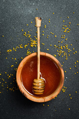 Bowl with honey, honey stick. The craft of beekeeping.