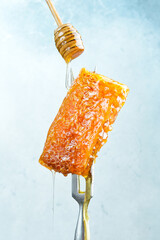 Honeycombs and Honey Stick. On a light background.