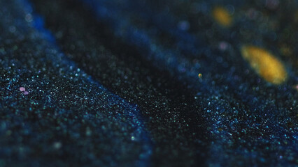 Sparkling ink spill. Paint drip. Glitter cascade. Defocused blue black golden color shiny particles...