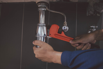 plumber at work in a bathroom, plumbing repair service , fix water plumbing leaks, replace the...