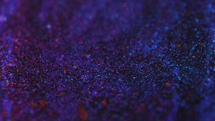 Sparkling paint flow. Glitter drops. Defocused blue red purple black color shimmering texture ink...