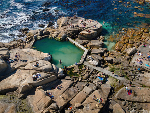Aerial view of swimmers and beach goers at Saunder&rsquo;s Rock tidal pool in summer in Bantry Bay, Atlantic Seaboard, Cape Town, South Africa.