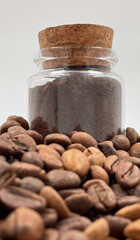Coffee beans ground in a coffee grinder, mortar or mill in a small glass jar on the table. Coarse or medium grind are packed for storage. A drink made from roasted and ground grains.
