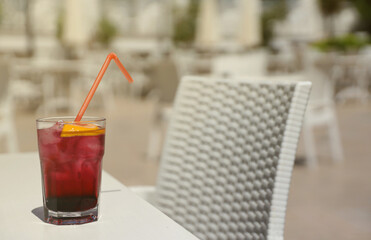 Pink and red Fresh colorful exotic alcoholic cocktail with lemon and ice on restaurant table. Colorful pink Soft drink with ice. Red colorful Mojito