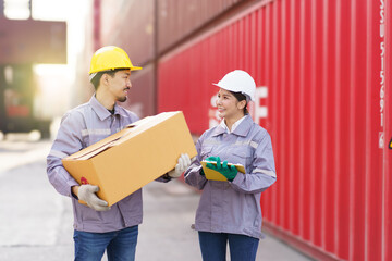 Team of logistic engineer working at the container yard. Asian female and male container yard worker talking - discussing together.